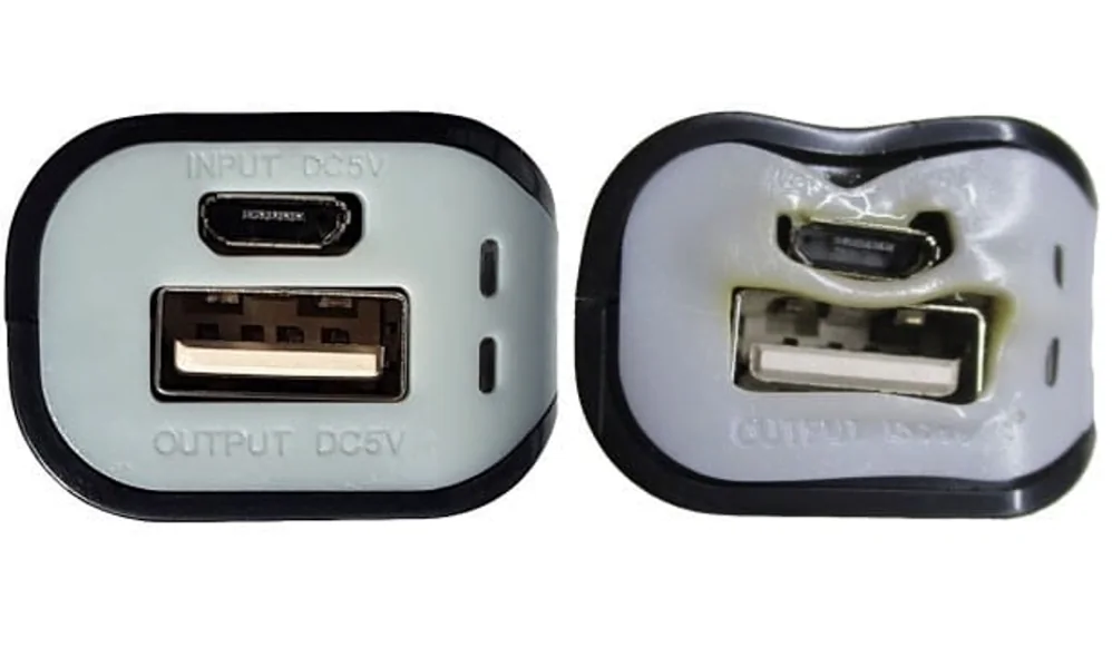Two power bank end caps side by side, one intact and one warped by heat around the USB and micro USB ports