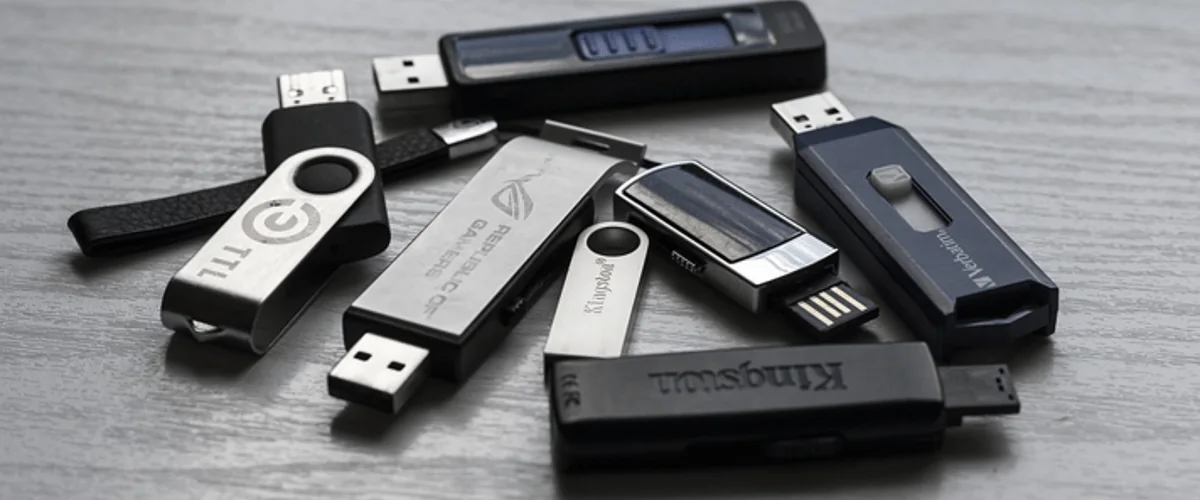 A collection of USB flash drives in different styles laid on a desk